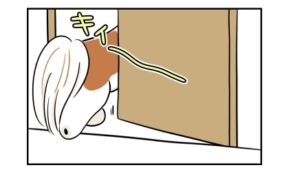 ドアの隙間から寝室に入る犬